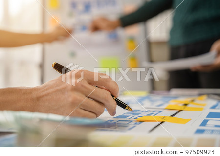 UI developer and ui designer brainstorming about mobile app interface wireframe design with customer breif and color code at office. 97509923