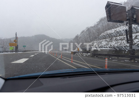 從小客車在覆蓋著小雪的高速公路上行駛的風景 97513031