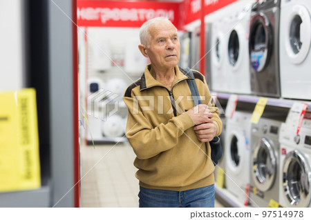 senor man pensioner buying washing machine in showroom of electrical appliance store senor man pensioner buying washing machine in showroom of electrical appliance store 97514978