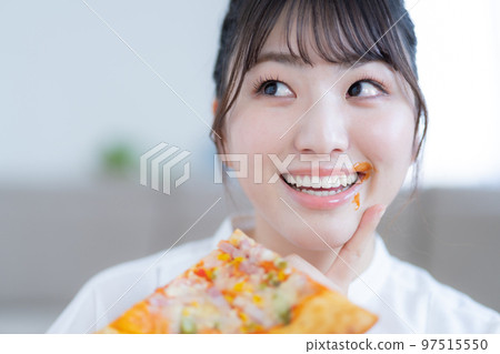 吃披薩的年輕女人嘴上沾著番茄醬 吃披薩的年輕女人嘴上沾著番茄醬 97515550