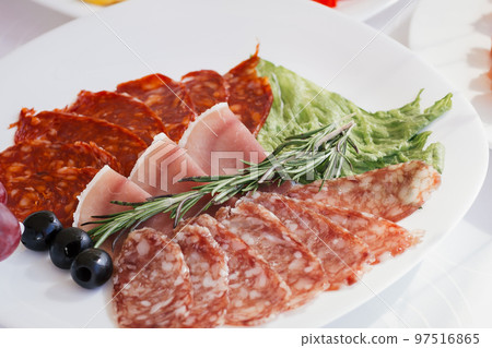 slices of sausage grapes on the festival table . slices of sausage grapes on the festival table . 97516865