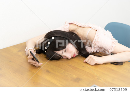Young woman lying down on the desk and crying 97518509