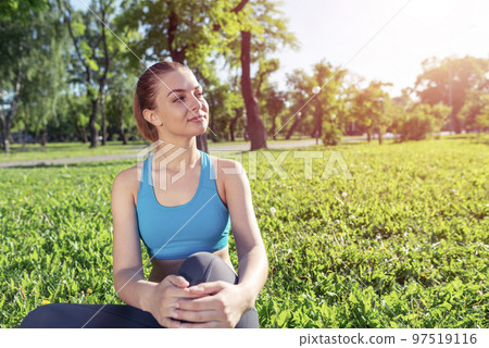 Beautiful smiling girl in activewear relax in park 97519116