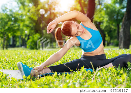 Attractive girl in sportswear doing yoga in park Attractive girl in sportswear doing yoga in park 97519117