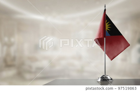 A small Antigua and Barbuda flag on an abstract blurry background 97519863