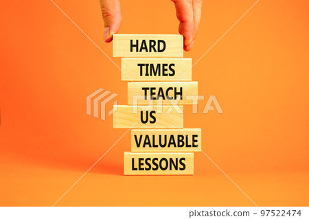 Lesson from hard times symbol. Concept words Hard times teach us valuable lessons on wooden blocks on a beautiful orange background. Businessman hand. Business lesson from hard times concept. Lesson from hard times symbol. Concept words Hard times teach us valuable lessons on wooden blocks on a beautiful orange background. Businessman hand. Business lesson from hard times concept. 97522474