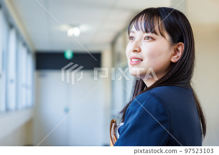 High school girl in uniform walking in the corridor 97523103