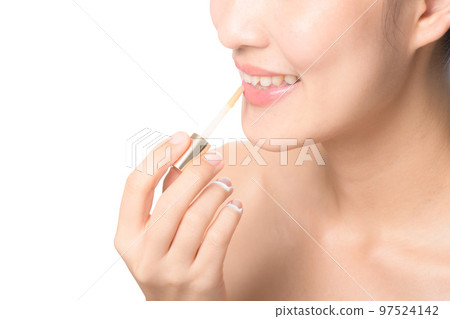 Beautiful portrait young asian woman looking mirror applying makeup lipstick at room. clipping path 97524142