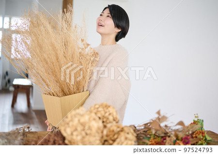 Young woman enjoying dried flowers Young woman enjoying dried flowers 97524793