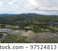 Aerial Top view from drone of the beautiful paddy fields with velvet green young sprouts in Balinese village. The traditional method for cultivating rice with flood the fields after setting young 97524813