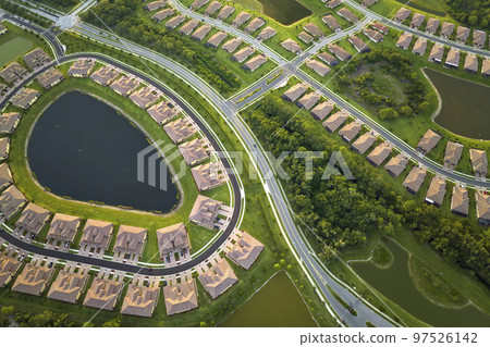 View from above of densely built residential houses near retention ponds in closed living clubs in south Florida. American dream homes as example of real estate development in US suburbs View from above of densely built residential houses near retention ponds in closed living clubs in south Florida. American dream homes as example of real estate development in US suburbs 97526142