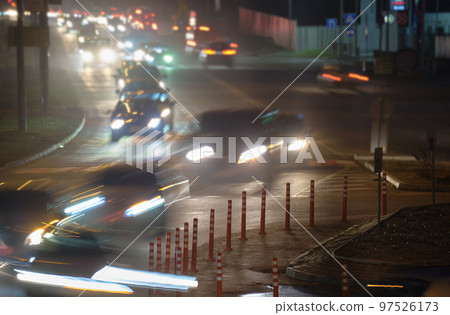 Traffic jam with many cars moving slowly on city street at night. Urban transportation concept Traffic jam with many cars moving slowly on city street at night. Urban transportation concept 97526173