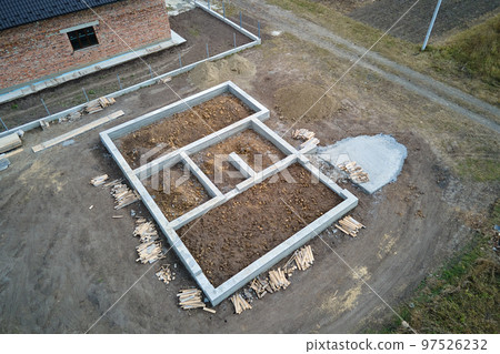 Top down aerial view of building works of new house concrete foundation on construction site Top down aerial view of building works of new house concrete foundation on construction site 97526232