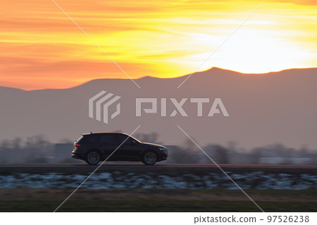 SUV car driving fast on intercity road at sunset. Highway traffic in evening SUV car driving fast on intercity road at sunset. Highway traffic in evening 97526238