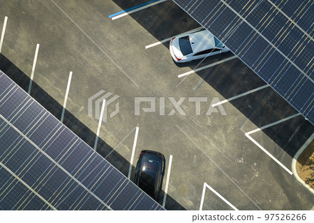Solar panels installed over parking lot for parked cars for effective generation of clean energy 97526266