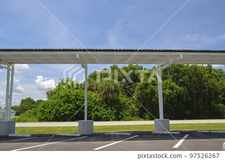 Solar panels installed over parking lot canopy shade for parked cars for effective generation of clean energy 97526267