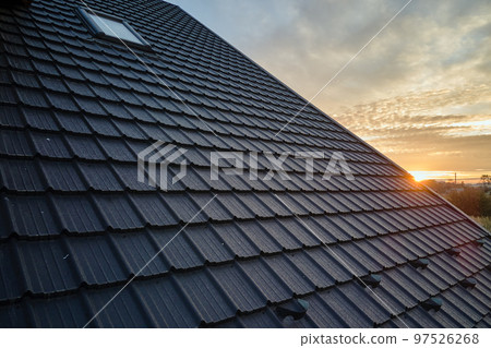 Snow guard for safety in winter on house roof top covered with steel shingles. Tiled covering of building 97526268