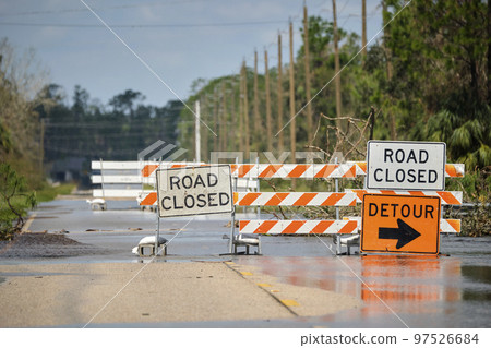 Road closed for roadworks and danger of flooding with warning signs blocking driving of cars Road closed for roadworks and danger of flooding with warning signs blocking driving of cars 97526684