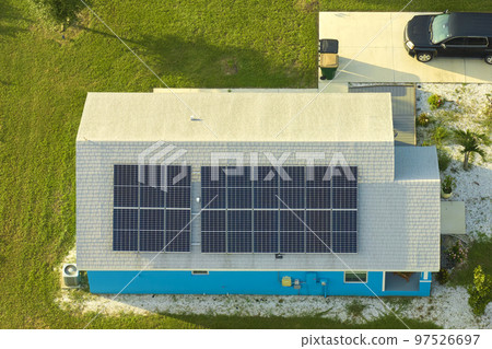 Residential house with rooftop covered with solar photovoltaic panels for producing of clean ecological electrical energy in suburban rural area. Concept of autonomous home 97526697