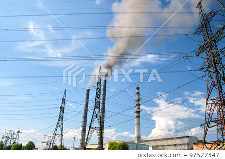 High voltage electric pylons against coal power plant high pipes with black smoke moving upwards polluting atmosphere. Production of electrical energy with fossil fuel concept High voltage electric pylons against coal power plant high pipes with black smoke moving upwards polluting atmosphere. Production of electrical energy with fossil fuel concept 97527347