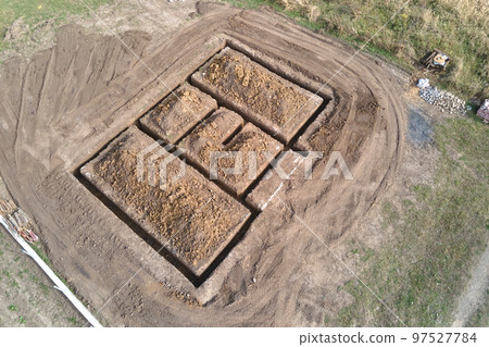 Dug out trench for building works of new house concrete foundation on construction site Dug out trench for building works of new house concrete foundation on construction site 97527784