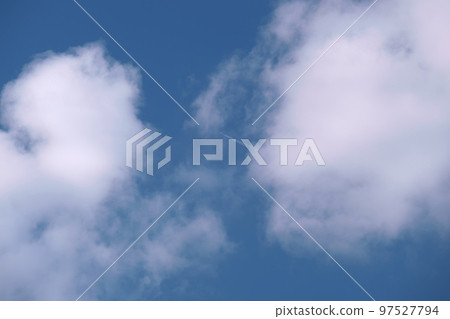 Distant passenger jet plane flying on high altitude on blue sky with white clouds leaving smoke trace of contrail behind. Air traveling concept. 97527794
