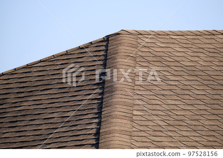 Closeup of house roof top covered with asphalt or bitumen shingles. Waterproofing of new building 97528156