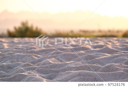 Close up of clean yellow sand surface covering seaside beach illuminated with evening light. Travel and vacations concept Close up of clean yellow sand surface covering seaside beach illuminated with evening light. Travel and vacations concept 97528176