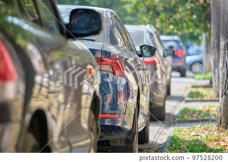 City traffic with cars parked in line on street side. City traffic with cars parked in line on street side. 97528200