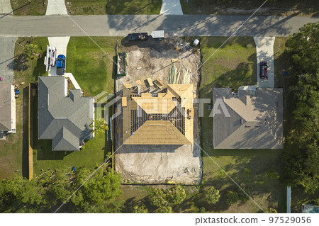 Aerial view of suburban private house wit wooden roof frame under construction in Florida quiet rural area Aerial view of suburban private house wit wooden roof frame under construction in Florida quiet rural area 97529056