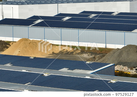 Aerial view of solar power plant with blue photovoltaic panels mounted on industrial building roof for producing green ecological electricity. Production of sustainable energy concept 97529127