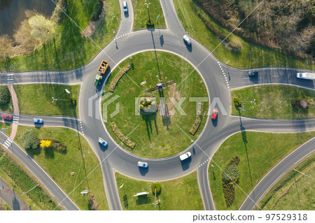 Aerial view of road roundabout intersection with moving heavy traffic. Urban circular transportation crossroads Aerial view of road roundabout intersection with moving heavy traffic. Urban circular transportation crossroads 97529318