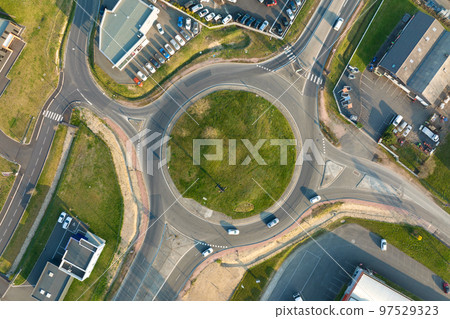 Aerial view of road roundabout intersection with moving heavy traffic. Urban circular transportation crossroads Aerial view of road roundabout intersection with moving heavy traffic. Urban circular transportation crossroads 97529323