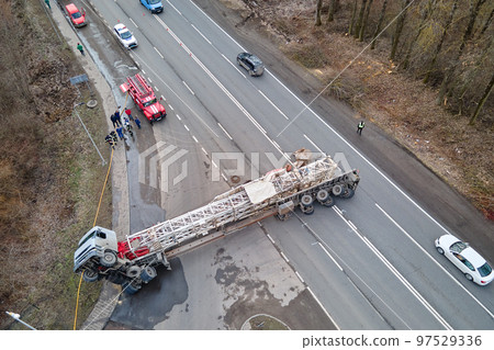 Aerial view of road accident with overturned truck blocking traffic Aerial view of road accident with overturned truck blocking traffic 97529336