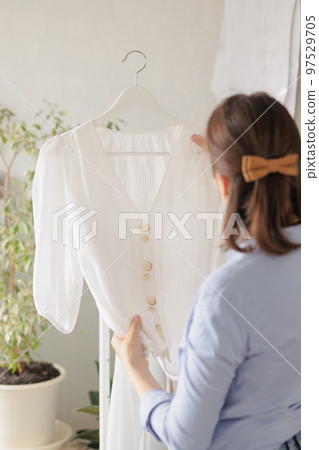 woman seamstress in workshop sews clothes for sale. cozy workplace, small business or hobby woman seamstress in workshop sews clothes for sale. cozy workplace, small business or hobby 97529705