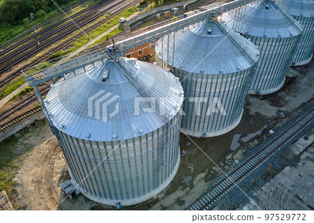 Aerial view of industrial ventilated silos for long term storage of grain and oilseed. Metal elevator for wheat drying in agricultural zone 97529772
