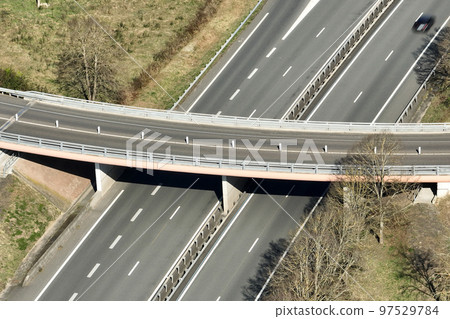 Aerial view of highway road intersection with fast moving heavy traffic. Intercity transportation with many cars and trucks Aerial view of highway road intersection with fast moving heavy traffic. Intercity transportation with many cars and trucks 97529784