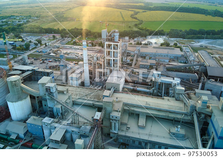 Aerial view of cement factory with high concrete plant structure and tower crane at industrial production site. Manufacture and global industry concept. Aerial view of cement factory with high concrete plant structure and tower crane at industrial production site. Manufacture and global industry concept. 97530053