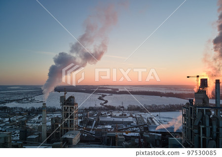 Aerial view of cement factory tower with high concrete plant structure at industrial production area at sunset. Manufacturing and global industry concept Aerial view of cement factory tower with high concrete plant structure at industrial production area at sunset. Manufacturing and global industry concept 97530085