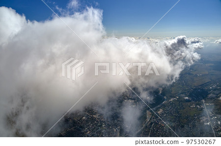 Aerial view from airplane window at high altitude of earth covered with puffy cumulus clouds forming before rainstorm. Aerial view from airplane window at high altitude of earth covered with puffy cumulus clouds forming before rainstorm. 97530267