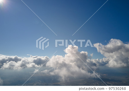 Aerial view from airplane window at high altitude of earth covered with puffy cumulus clouds forming before rainstorm Aerial view from airplane window at high altitude of earth covered with puffy cumulus clouds forming before rainstorm 97530268