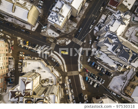 Aerial black and white winter top view of modern city with tall buildings, parked and moving cars along streets with road marking. Urban cityscape, view from above. Aerial black and white winter top view of modern city with tall buildings, parked and moving cars along streets with road marking. Urban cityscape, view from above. 97530318