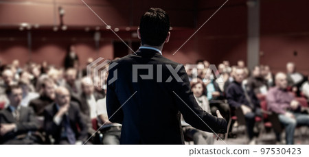 Speaker giving a talk on corporate business conference. Unrecognizable people in audience at conference hall. Business and Entrepreneurship event. Speaker giving a talk on corporate business conference. Unrecognizable people in audience at conference hall. Business and Entrepreneurship event. 97530423
