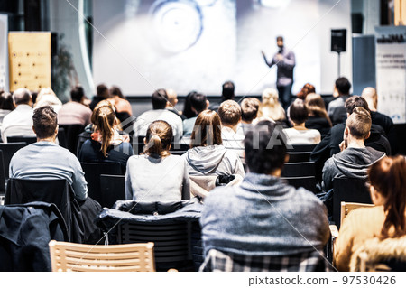Speaker giving a talk in conference hall at business event. Audience at the conference hall. Business and Entrepreneurship concept. Focus on unrecognizable people in audience. Speaker giving a talk in conference hall at business event. Audience at the conference hall. Business and Entrepreneurship concept. Focus on unrecognizable people in audience. 97530426