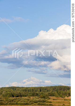 Rural landscape with forest under cloudy sky Rural landscape with forest under cloudy sky 97530438