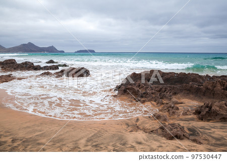Coastal landscape with wet rocks and shore water on the beach 97530447