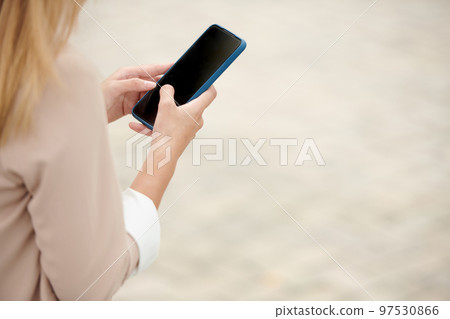Hands of female entrepreneur answering messages on sartphone 97530866