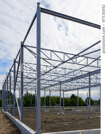 Assembled steel framework of new modern industrial building with foundation concrete panel border 97530892