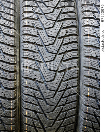 New modern studdable winter tire tread closeup withouts studs New modern studdable winter tire tread closeup withouts studs 97530976