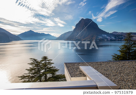 Sunny View on lake Lugano and good residential buildings on shore with fantastic cedar tree Sunny View on lake Lugano and good residential buildings on shore with fantastic cedar tree 97531979